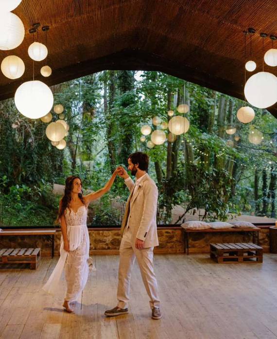 Pareja bailando en una pista cubierta abierta hacia el bosque, perfecto para bodas en la naturaleza.