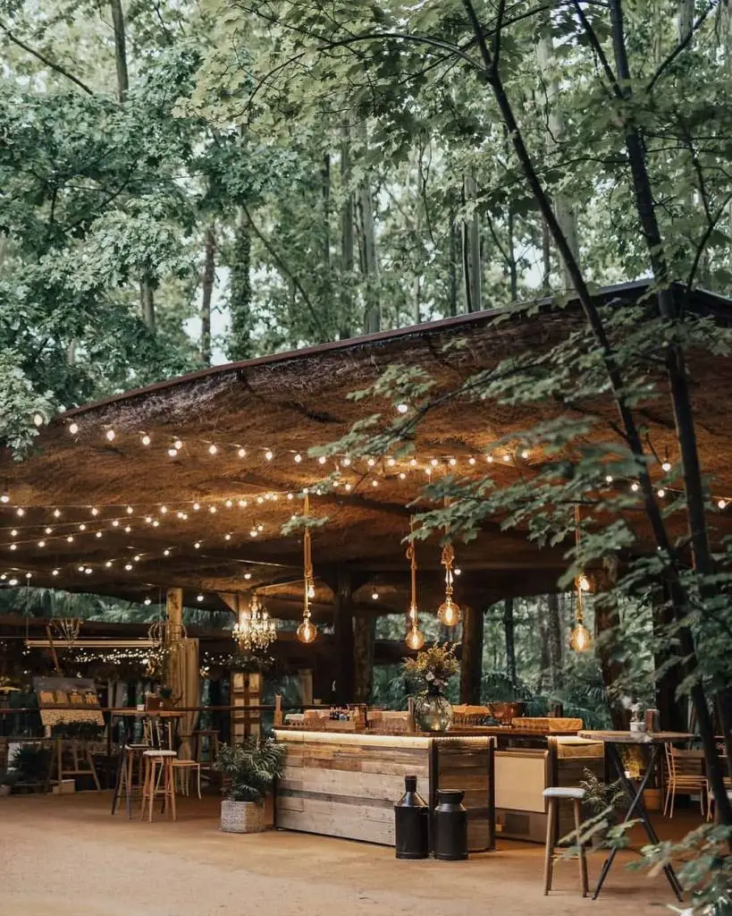 Barra de bar exterior iluminada bajo techo rústico para bodas en la naturaleza en la Vinyassa